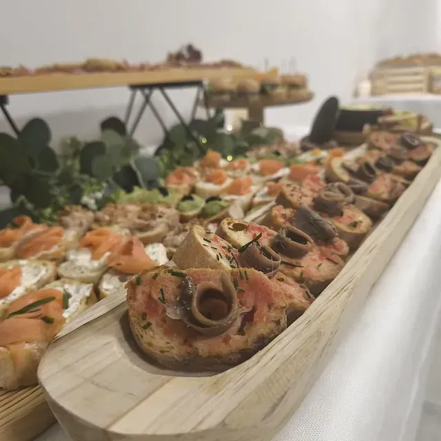 Una bandeja de madera llena de una variedad de alimentos sobre una mesa.