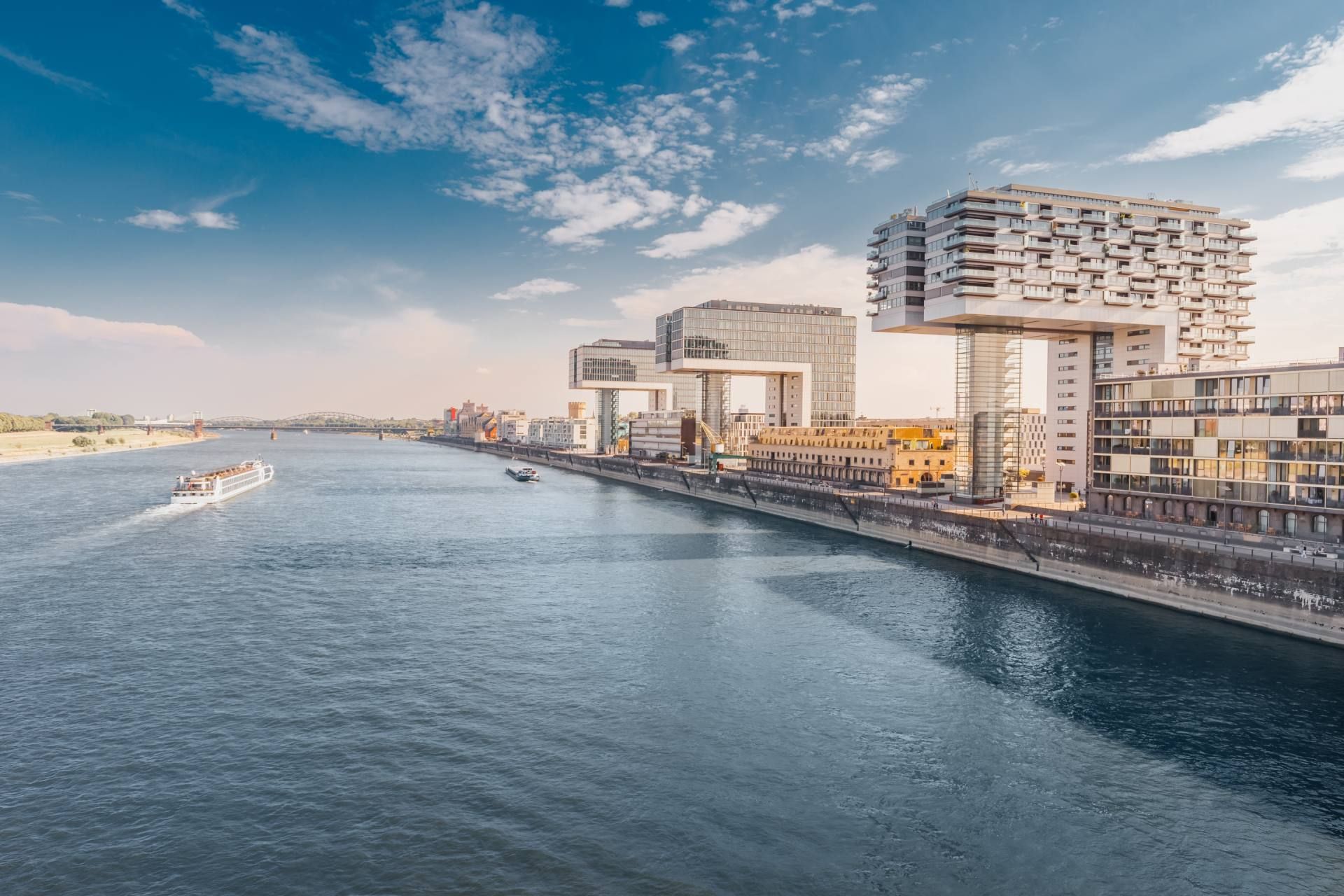 Ein Boot fährt auf einem Fluss in der Nähe eines großen Gebäudes  in Köln