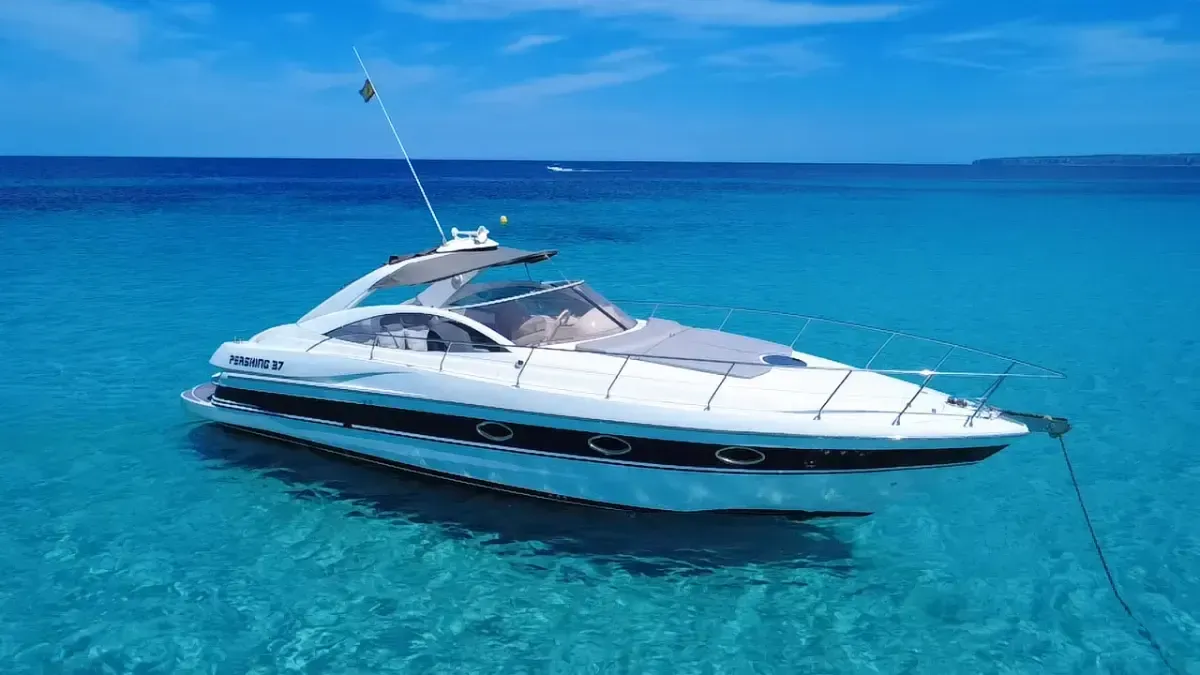 Un lujoso yate blanco flotando en aguas cristalinas de color turquesa cerca de un horizonte azul.