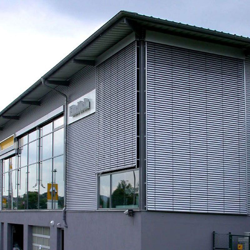 Ein graues Gebäude mit einem Schild an der Seite, auf dem 000 steht