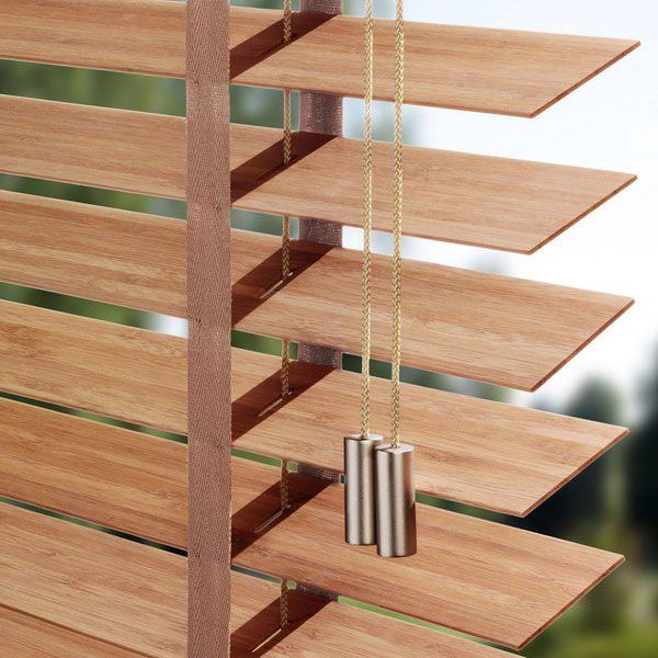 Eine Nahaufnahme einer Holzjalousie mit einem daran hängenden Seil