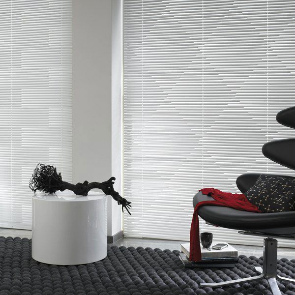 Ein Wohnzimmer mit einem schwarzen Stuhl und einem weißen Tisch