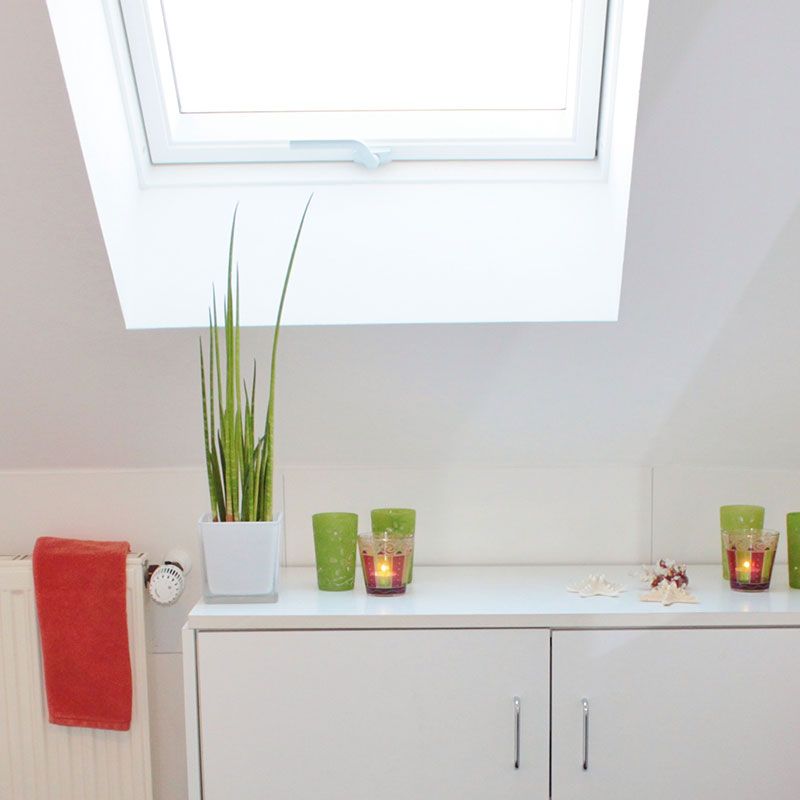 Ein Badezimmer mit einer Pflanze und Kerzen auf der Ablage