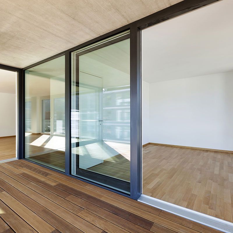 Ein leerer Raum mit Glasschiebetüren und Holzboden