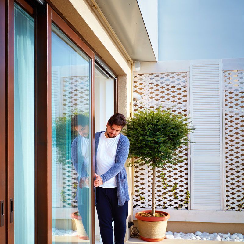 Ein Mann steht vor einer Glasschiebetür