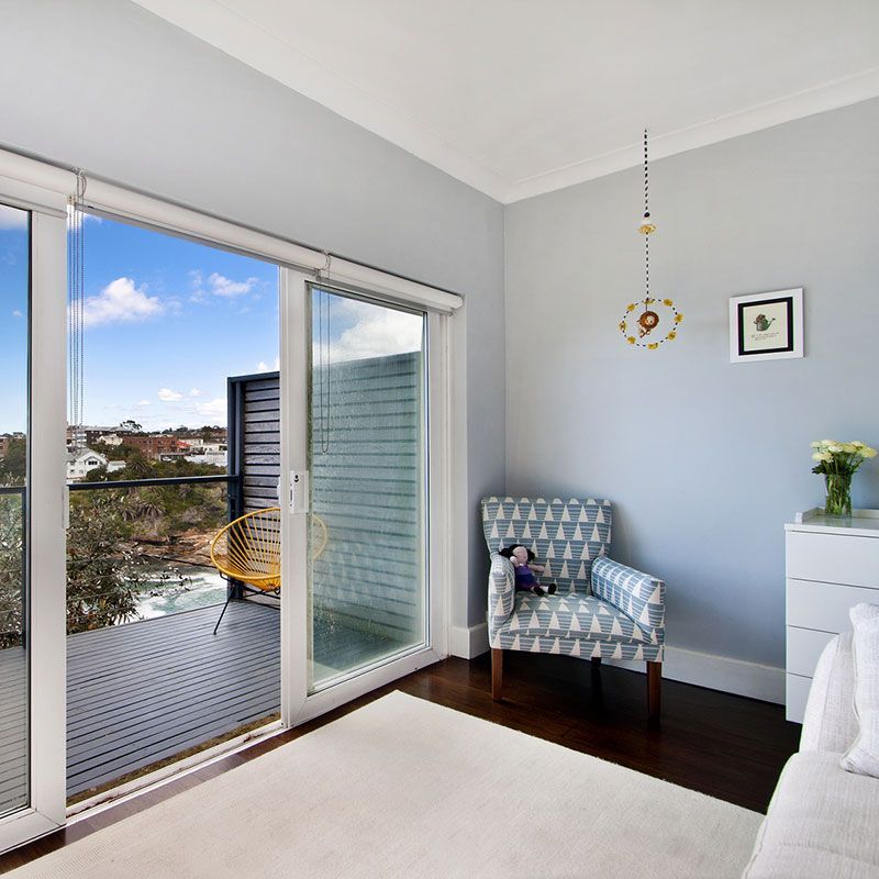 Ein Wohnzimmer mit Glasschiebetüren, die auf einen Balkon führen