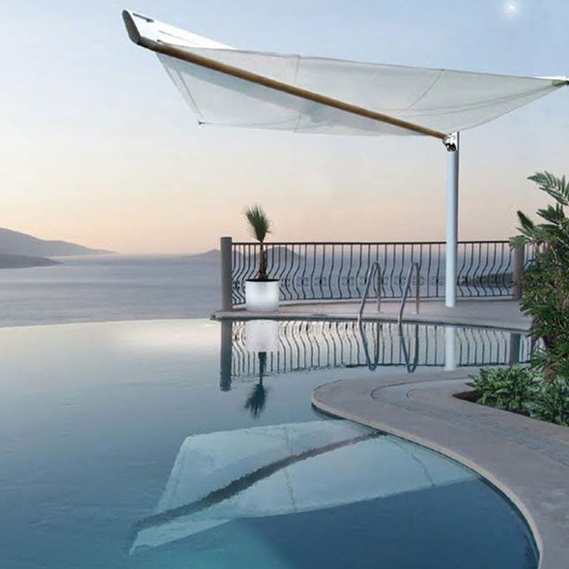 Ein Swimmingpool mit Sonnenschirm darüber und Blick auf das Meer