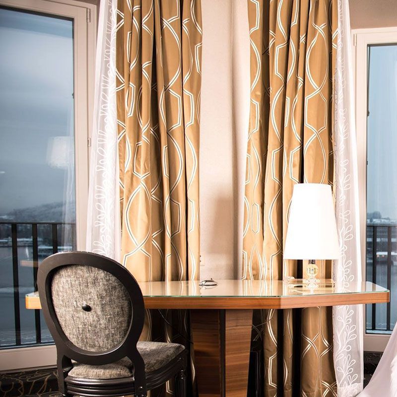 Ein Hotelzimmer mit einem Tisch und Stühlen und einer Lampe