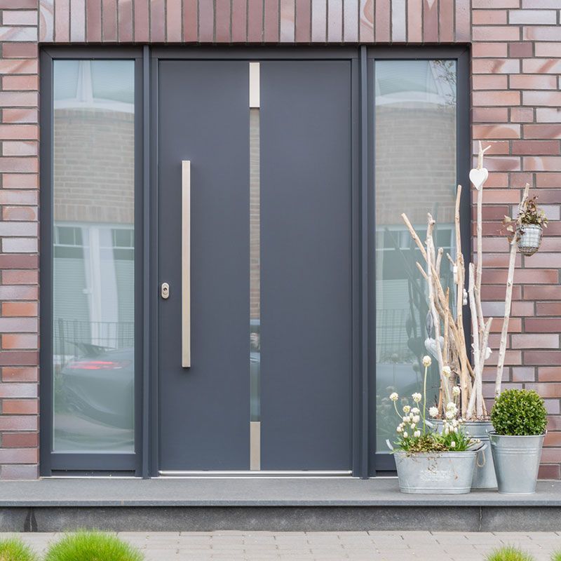 Die Eingangstür eines Backsteinhauses mit einer schwarzen Tür