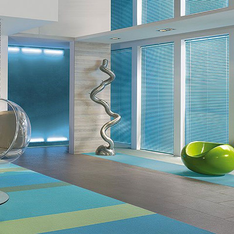 Ein Wohnzimmer mit blauen Jalousien und einem grünen Stuhl