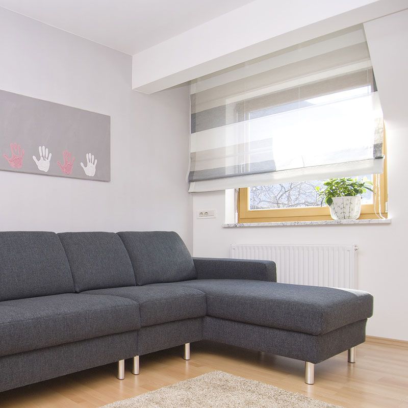 Ein Wohnzimmer mit Sofagarnitur und Fenster