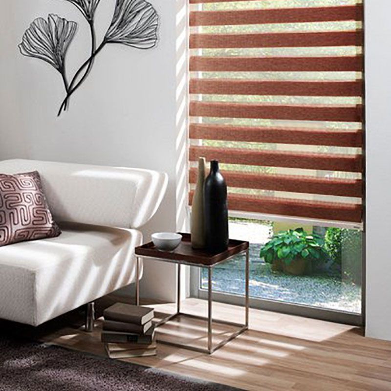 Ein Wohnzimmer mit Couch, Tisch, Vasen und Fenster.