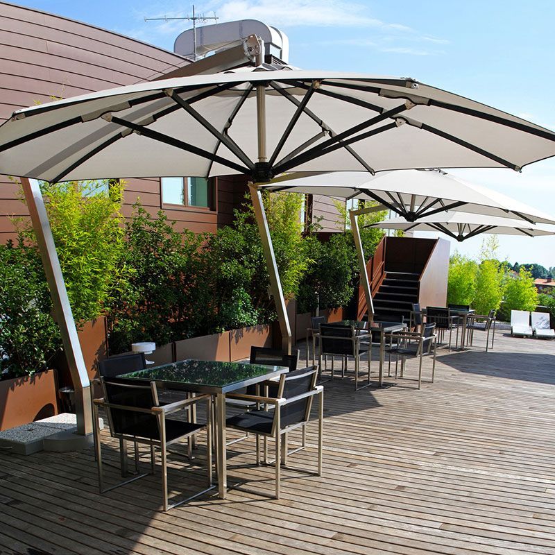 Eine Terrasse mit Tischen und Stühlen unter Sonnenschirmen