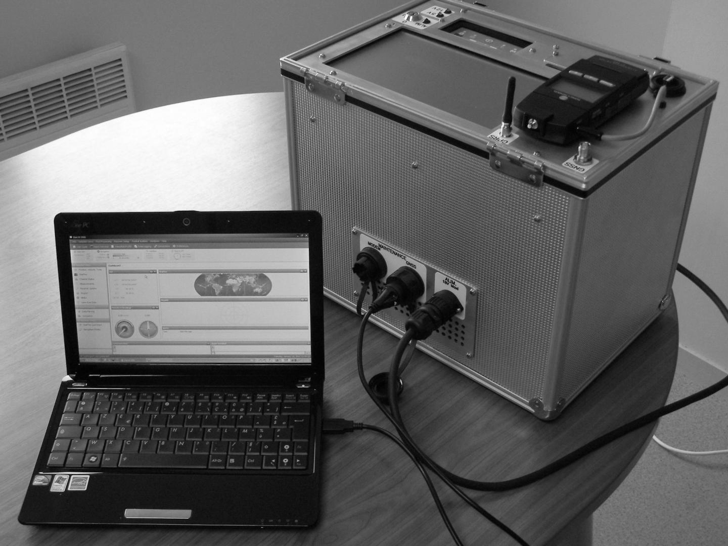 Un ordinateur portable branché à un outil de géomètre