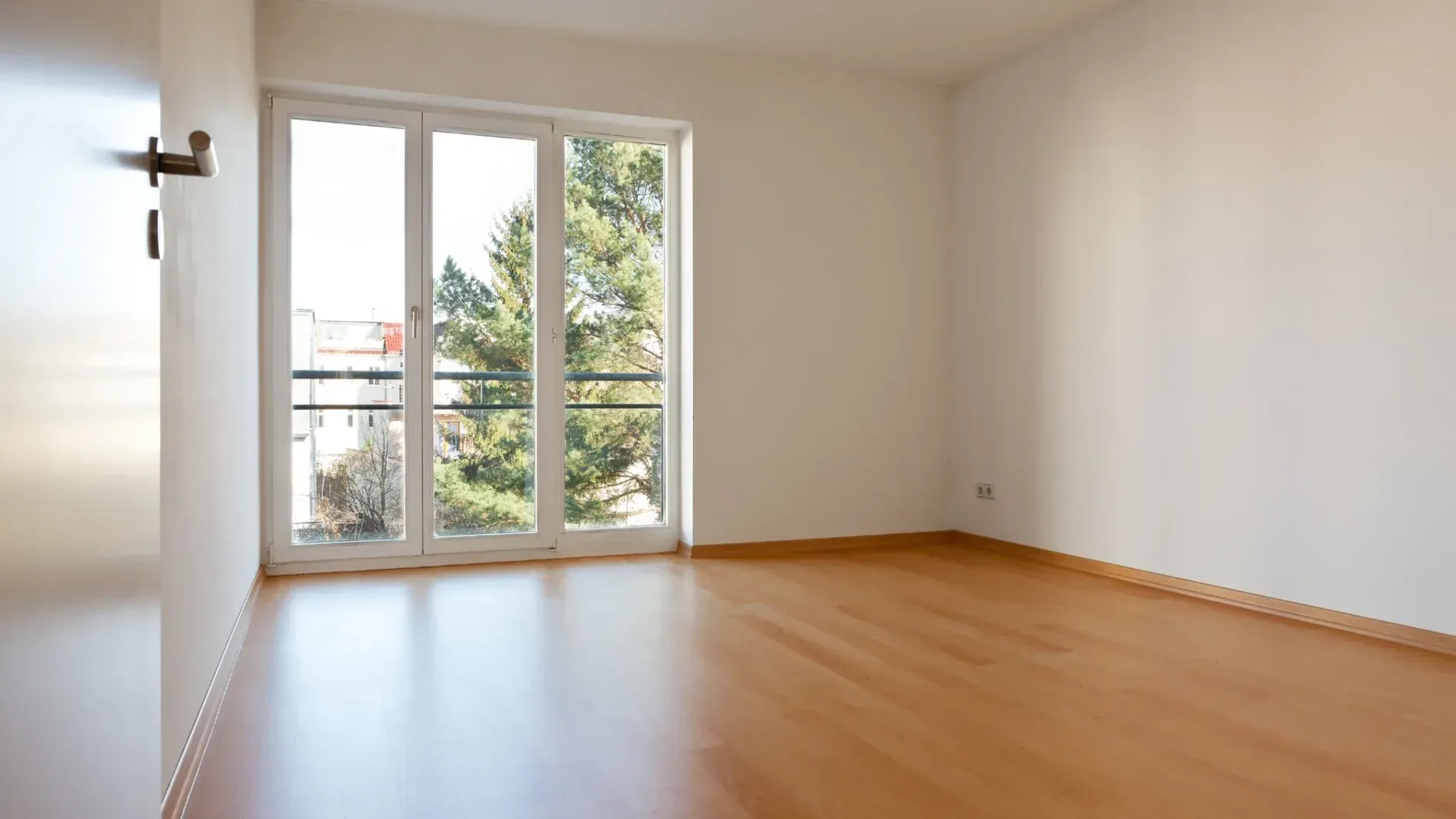 Persona usando un destornillador en la cerradura de una puerta. Hay un llavero con llaves en la cerradura.