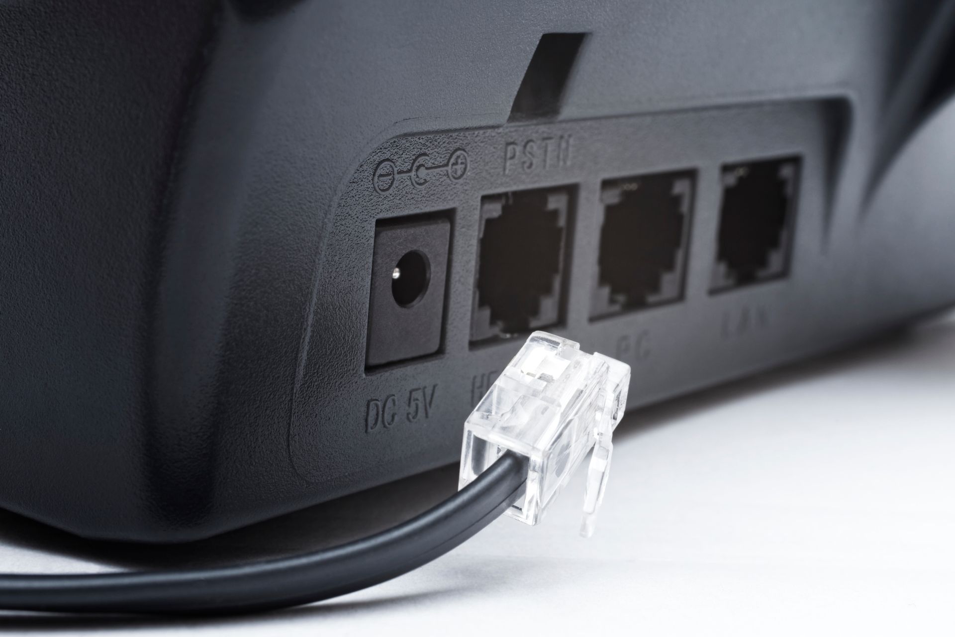 Eine Person repariert einen Lichtschalter mit einem Schraubenzieher.