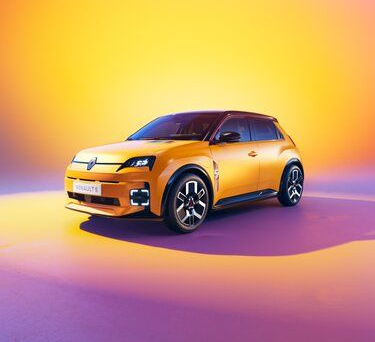 Une voiture orange sur un fond multicolore : les couleurs d'un coucher de soleil.