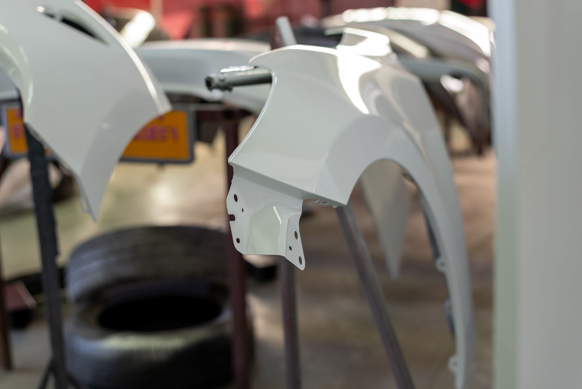 Des panneaux de carrosserie blancs dans un atelier de réparation automobile.