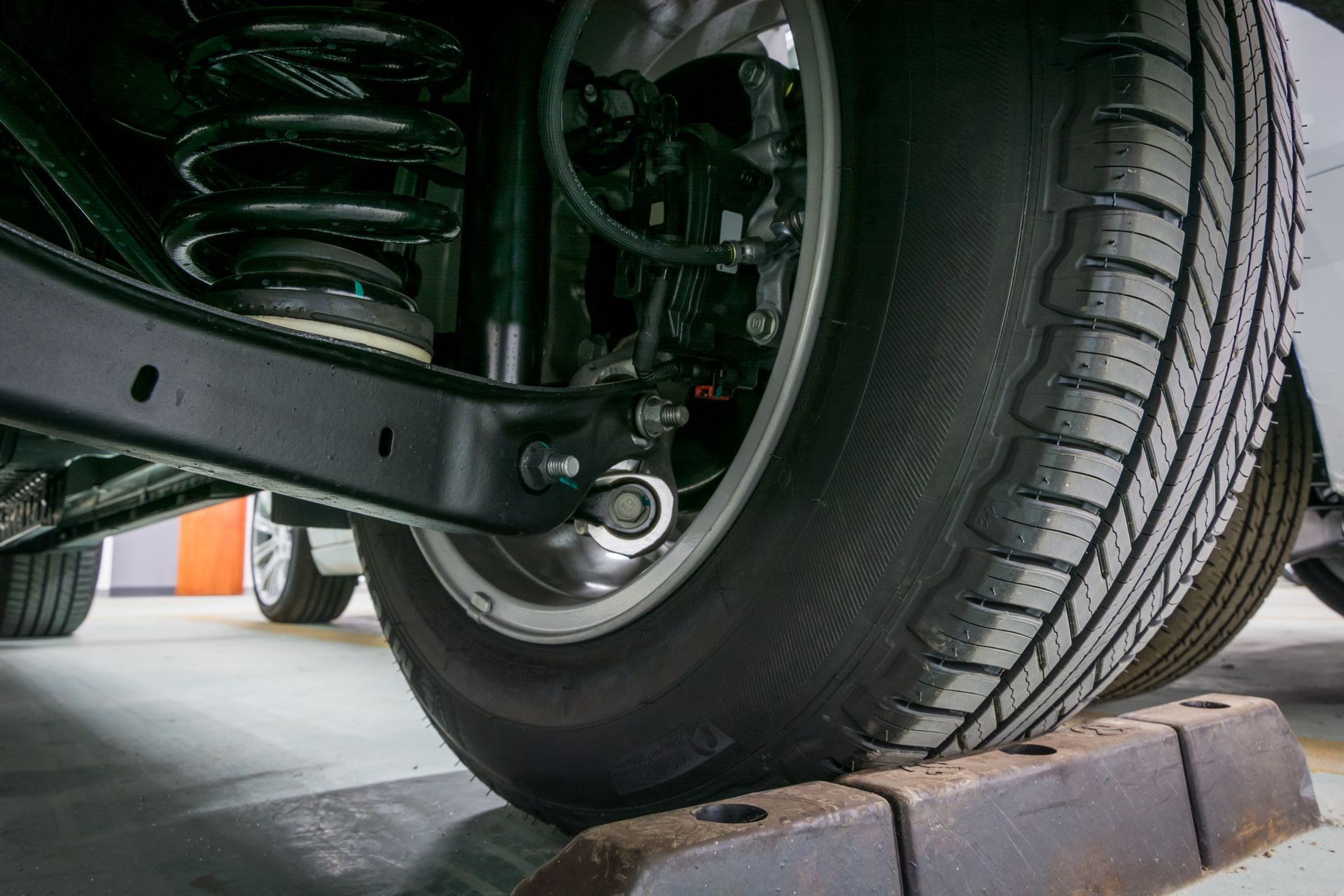 Gros plan sur la roue arrière et la suspension d’une voiture.