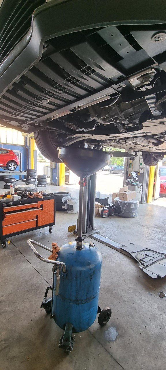 Vidange d'une voiture dans un atelier mécanique.
