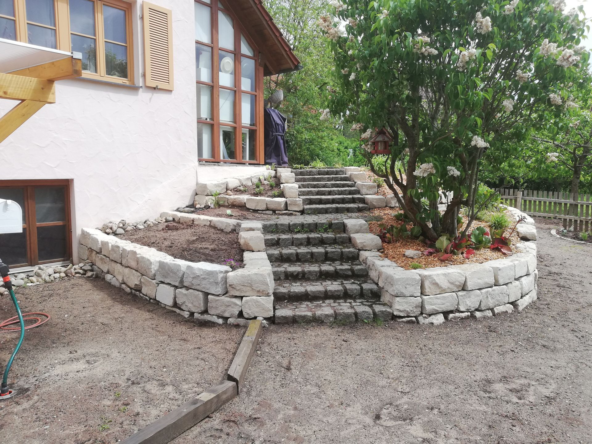 Vorgarten eines Hauses mit gepflastertem Weg und Steintreppen