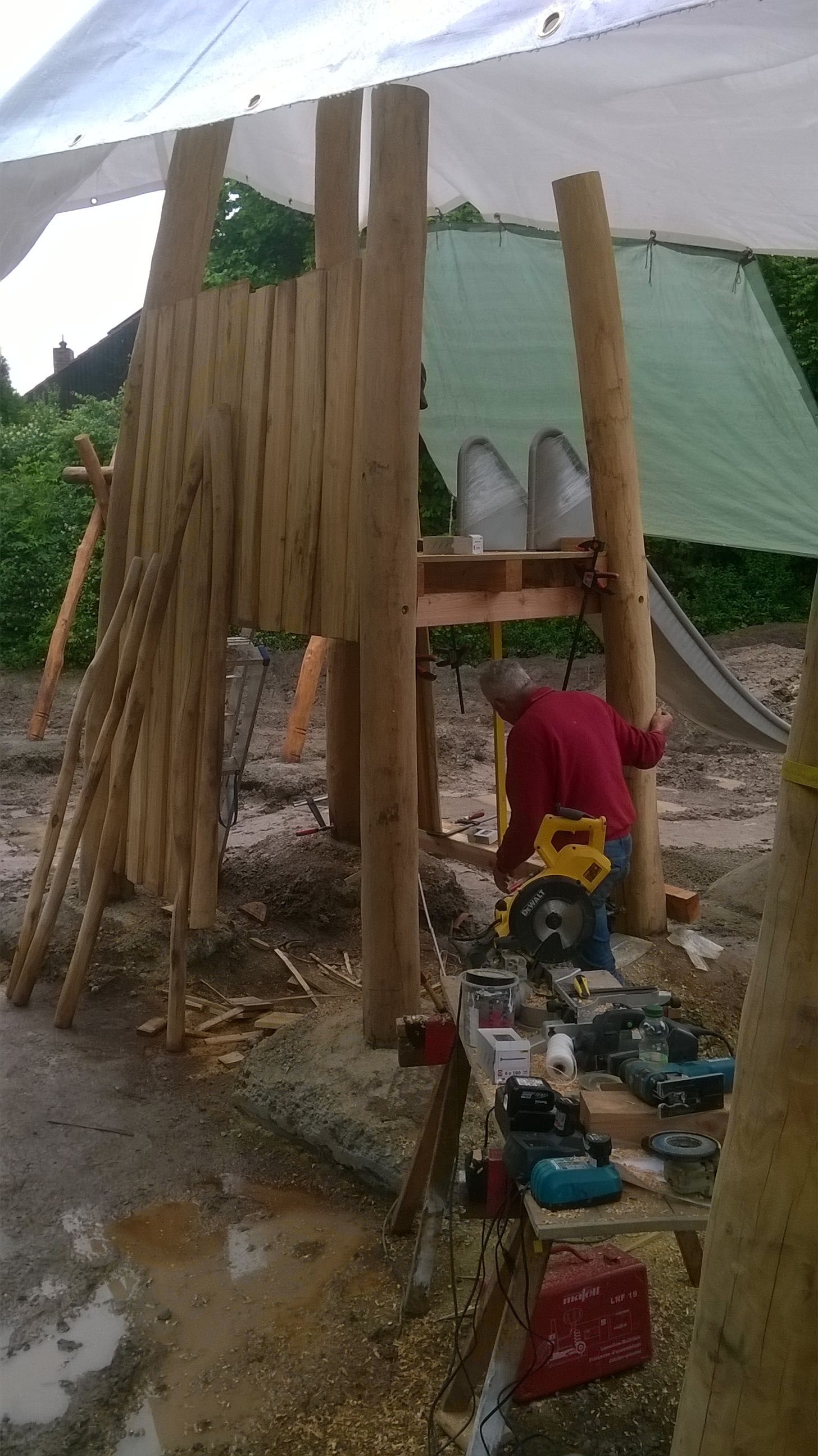 ein Mann baut ein Klettergerüst aus Holz