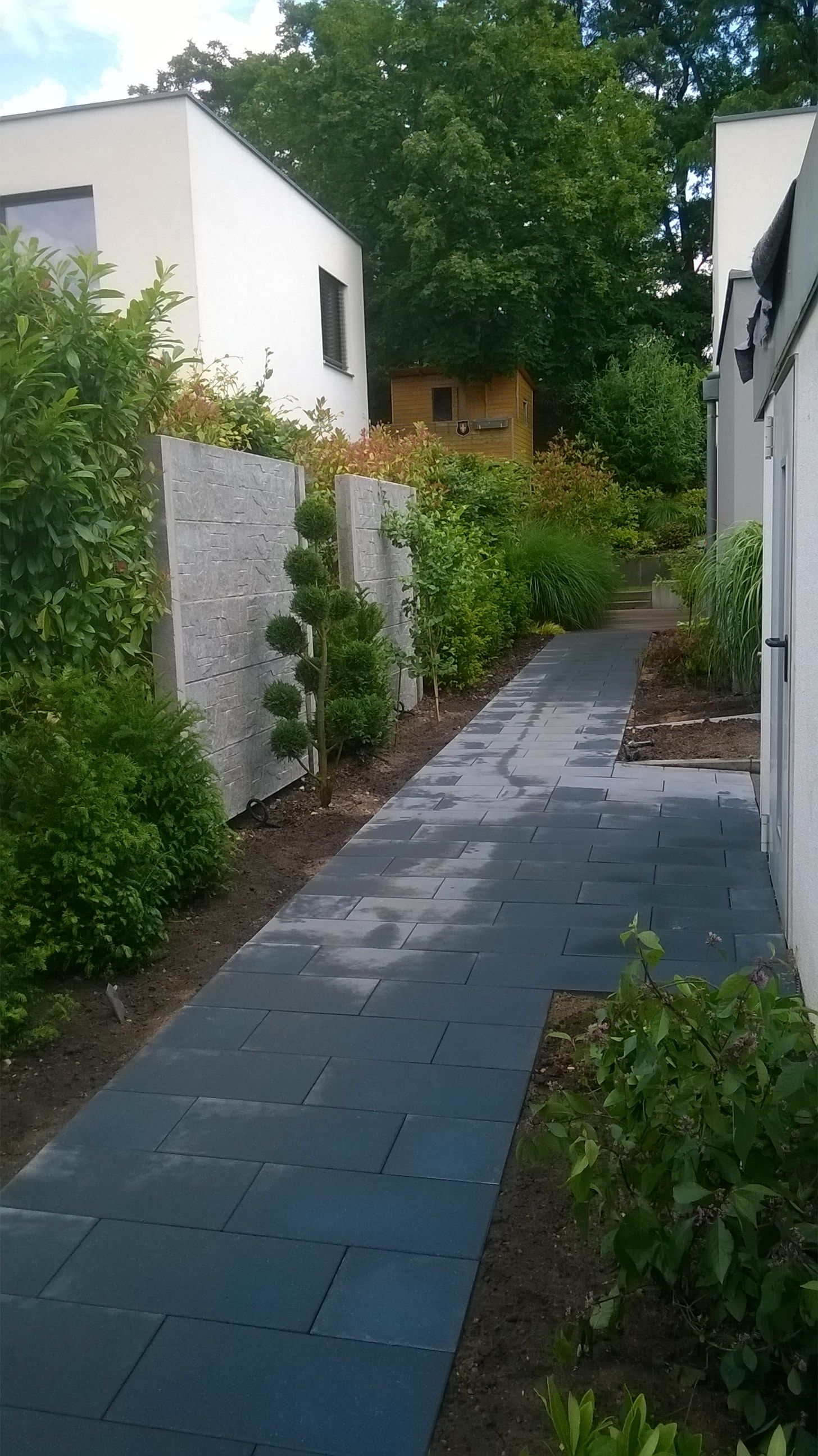 gepflasterter Weg entlang eines modernen Hauses