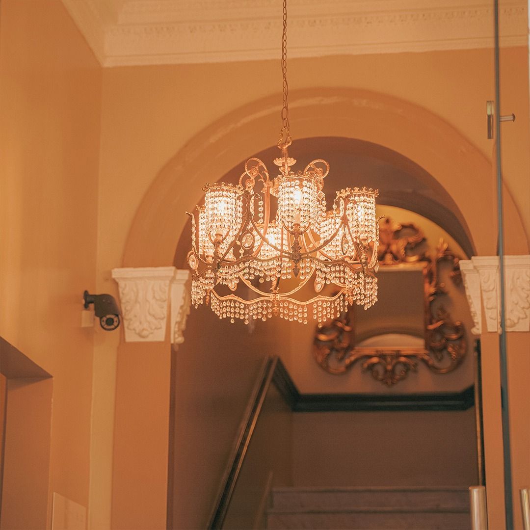 Una escalera con una lámpara de araña colgando del techo.