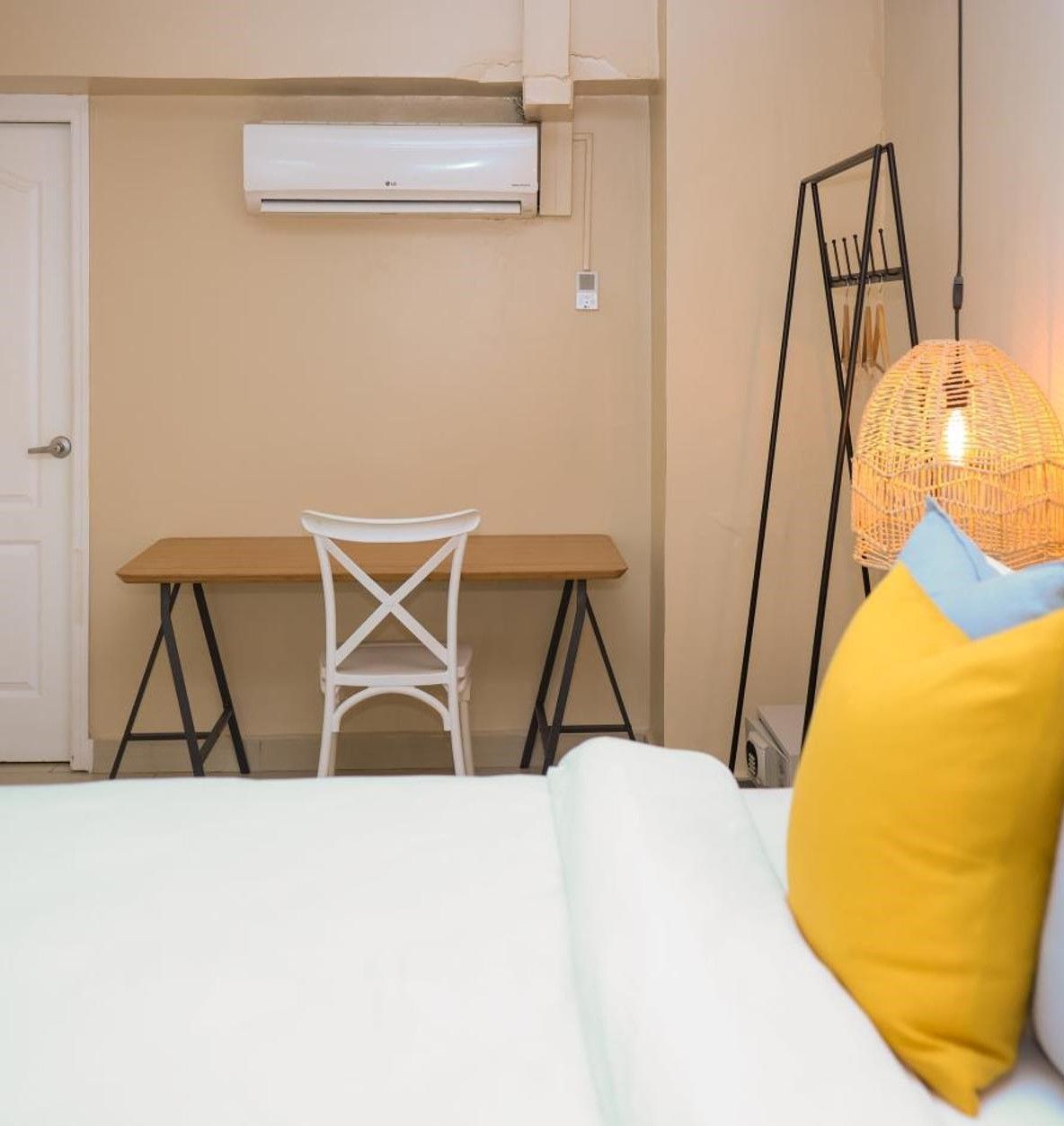 Un dormitorio con una cama, un escritorio y una silla.