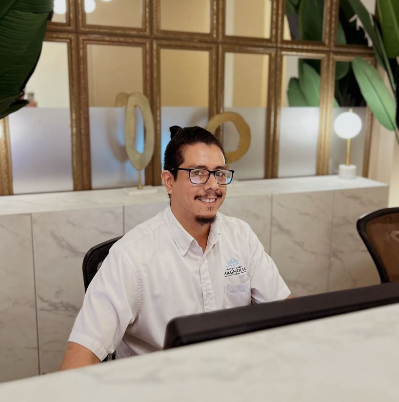 Un hombre con gafas está sentado frente a una computadora.