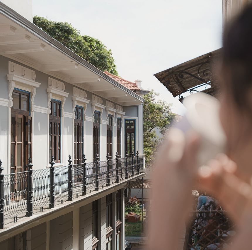 Una persona tomando una fotografía de un edificio con balcón