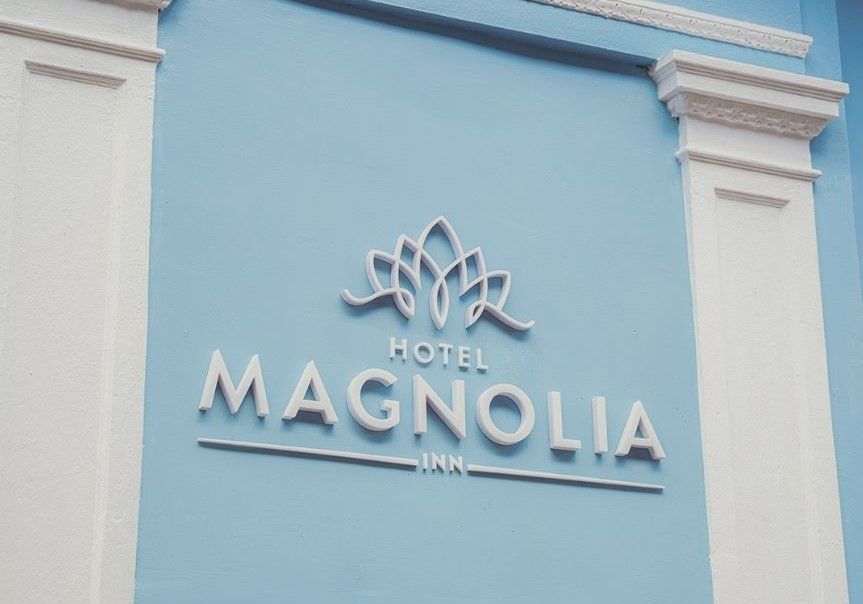 Un cartel azul y blanco para el hotel Magnolia Inn.