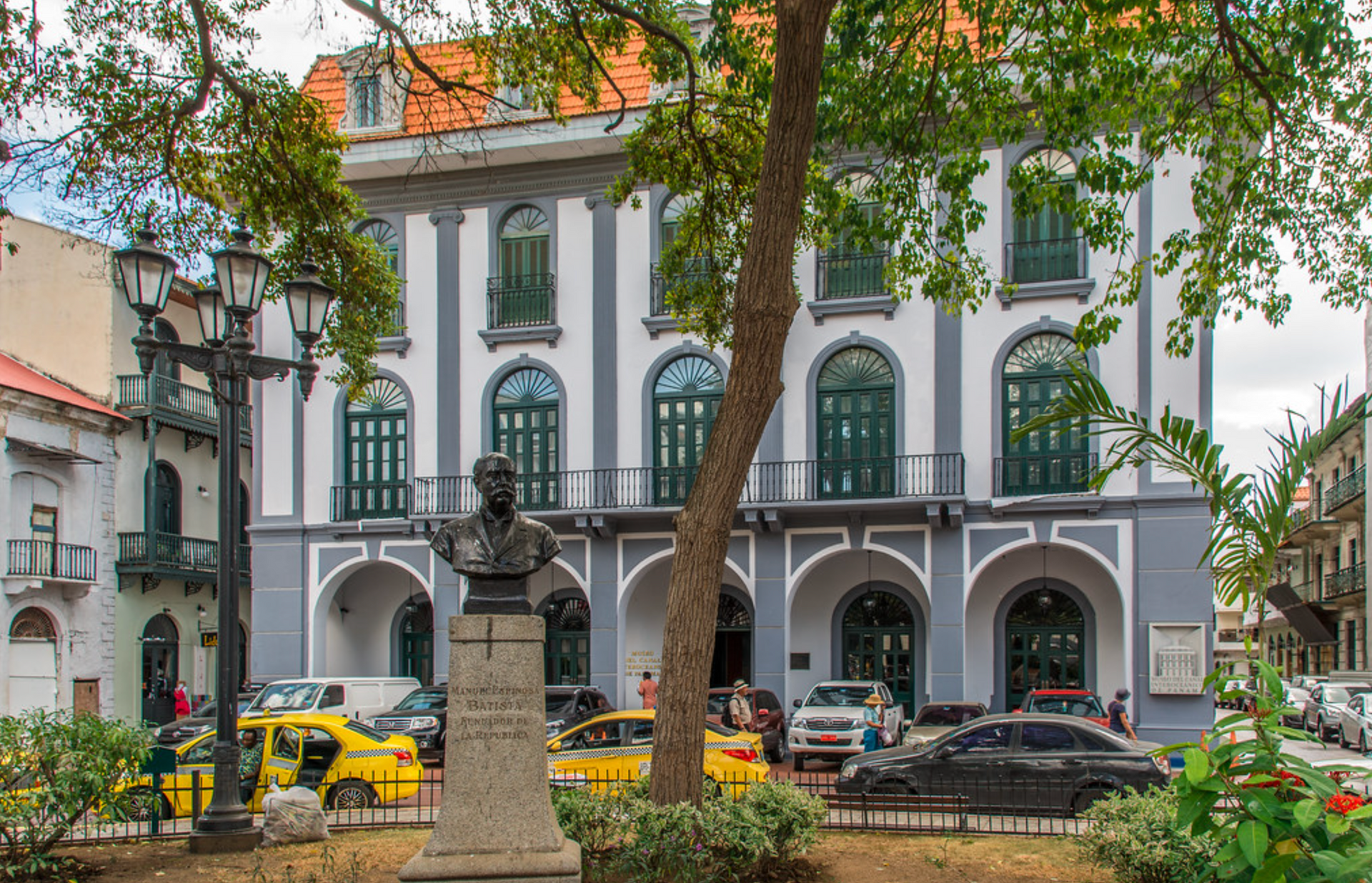 Una estatua de un hombre está frente a un gran edificio.