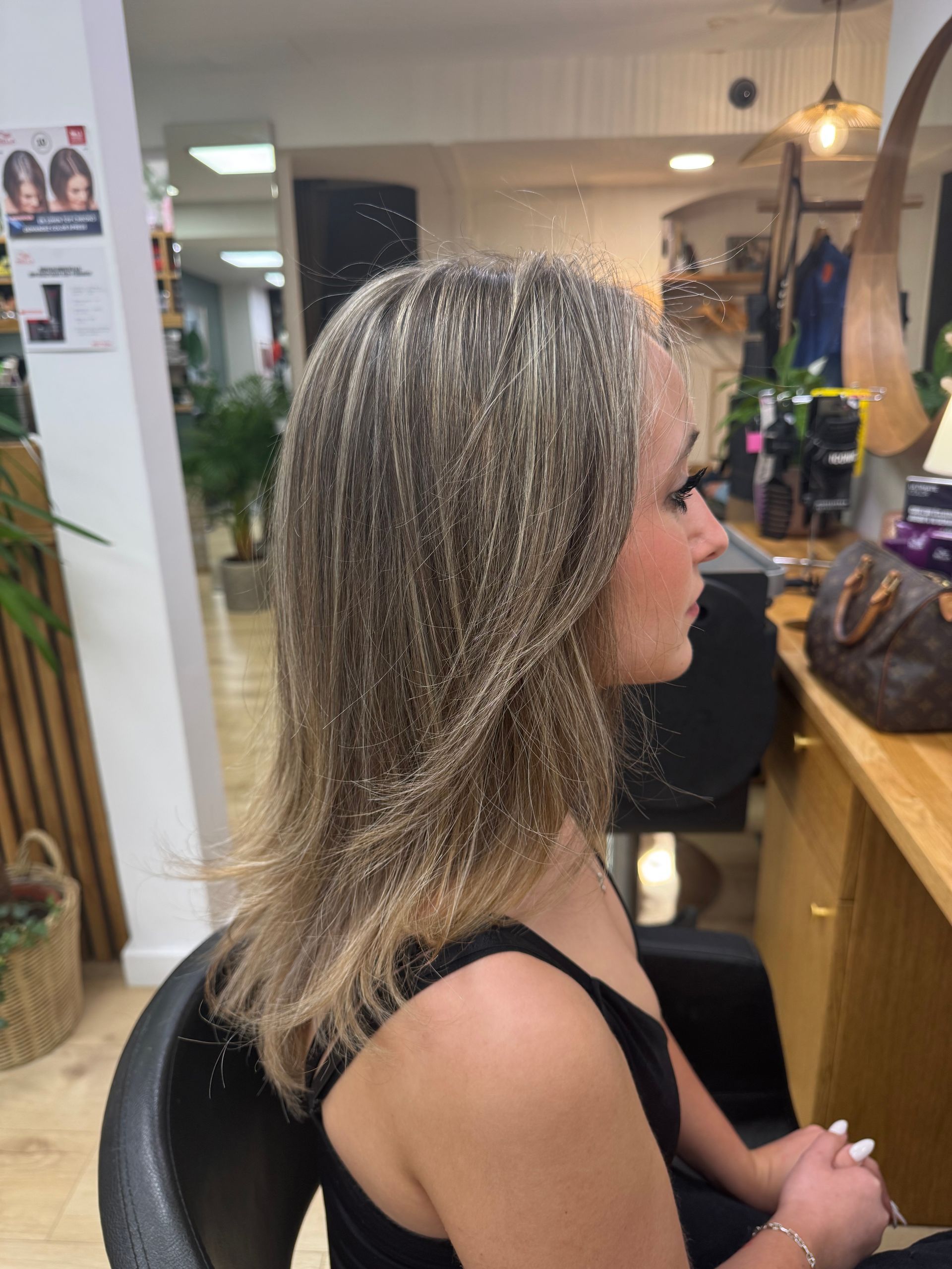 Femme aux longs cheveux blonds assise sur un fauteuil de salon