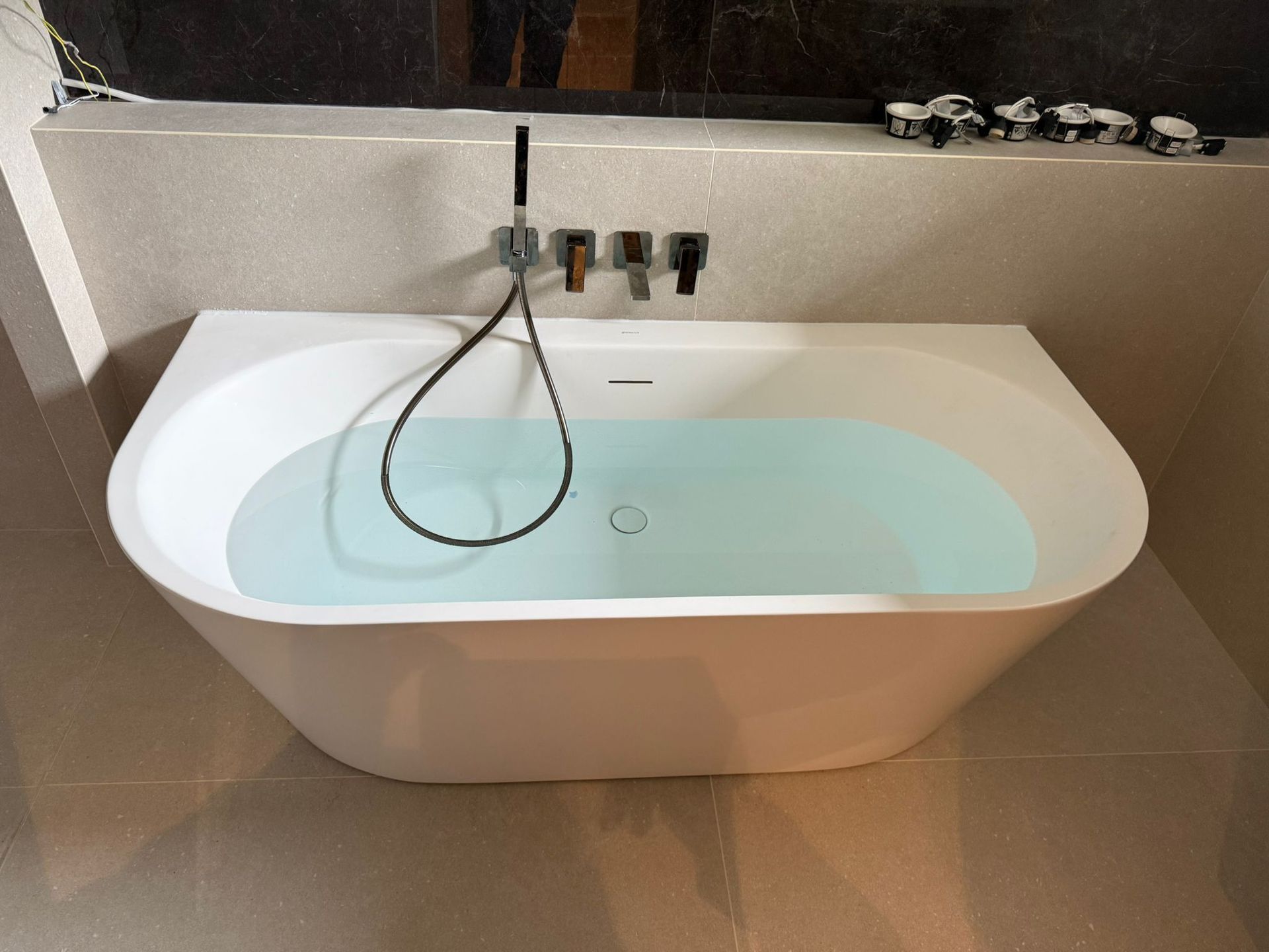 Baignoire en îlot moderne dans une salle de bains haut de gamme aux finitions élégantes et design contemporain.