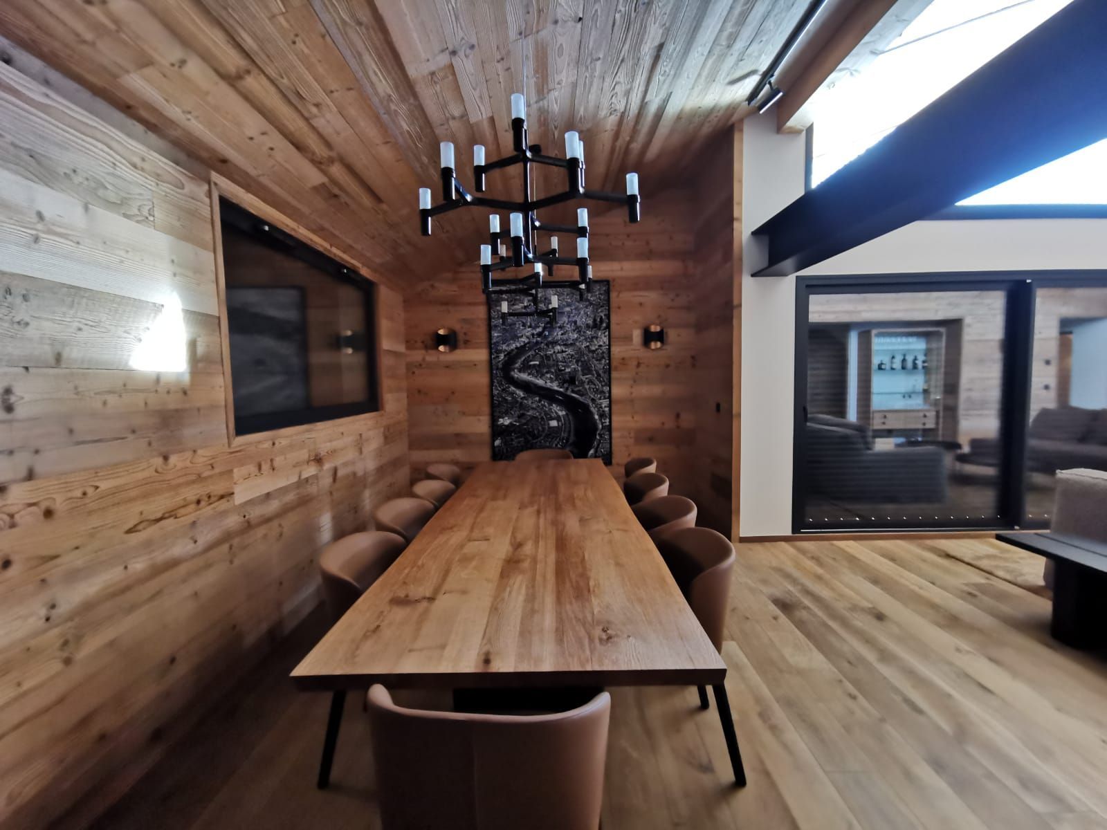 Salle à manger chaleureuse dans un chalet de montagne avec grande table en bois, décoration contemporaine et ambiance conviviale.