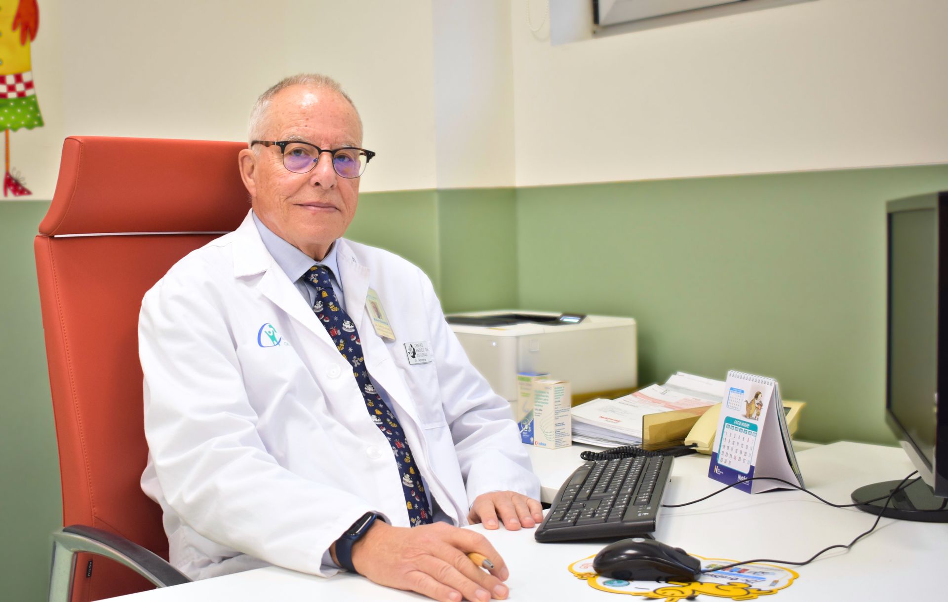 Mujer en un mostrador de recepción mirando su teléfono, sonriendo, con otra persona frente a ella.