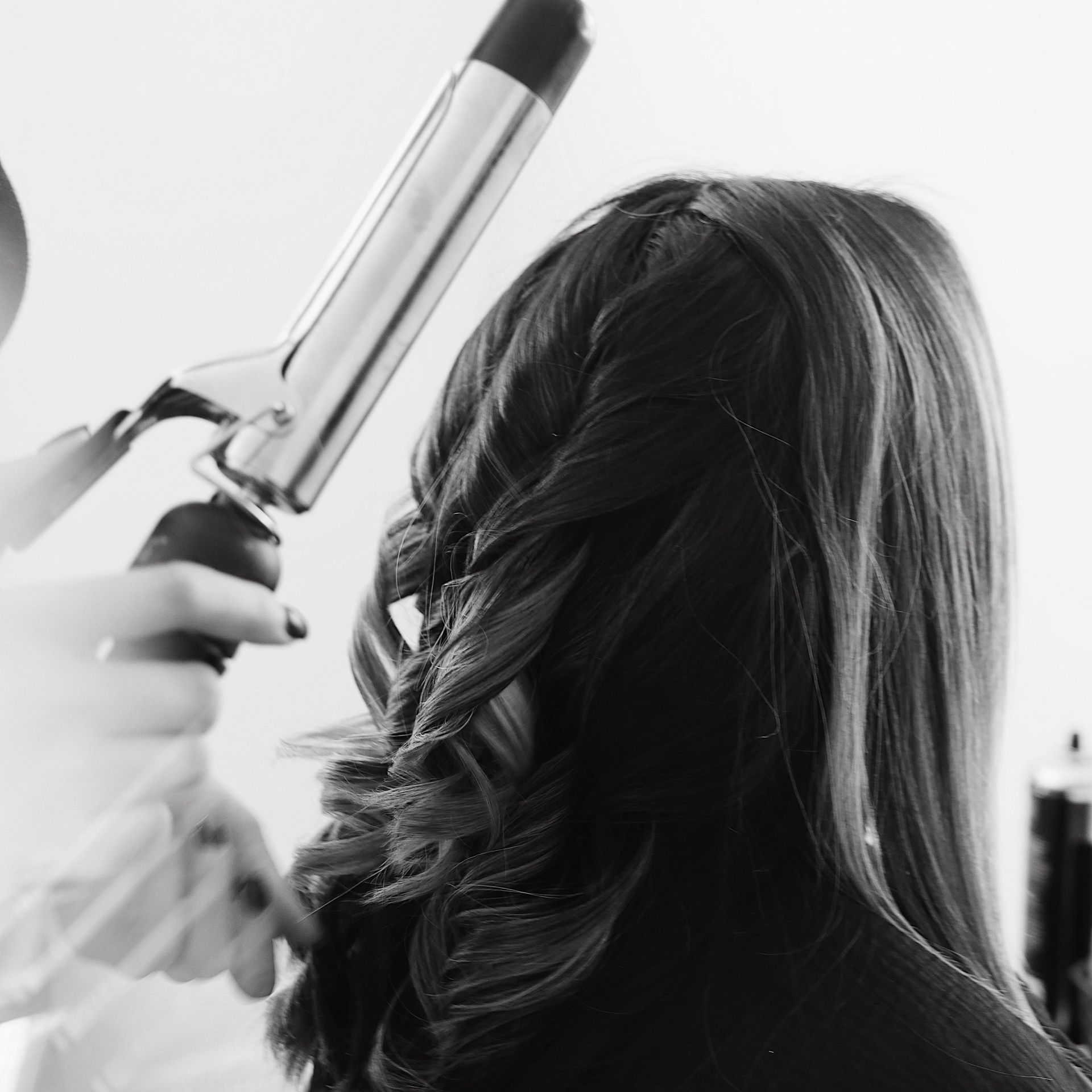 Eine Frau schneidet Haare mit Schere und Kamm.