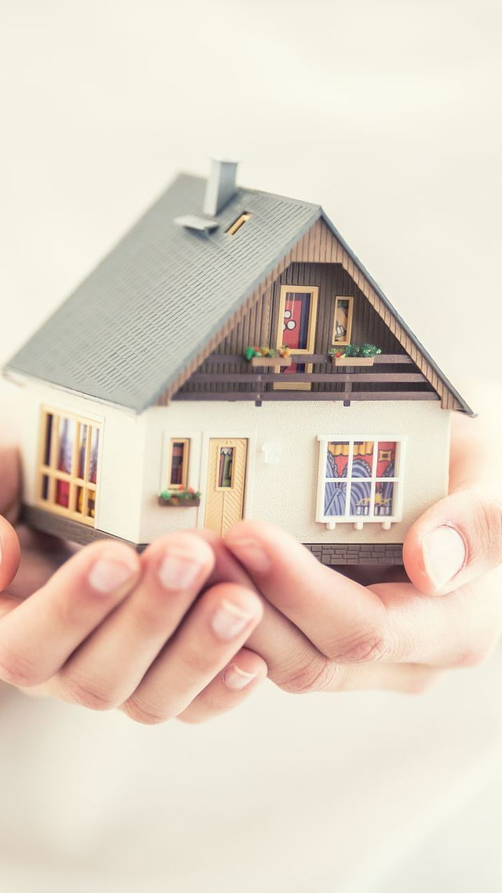 Maison en statuette dans des mains