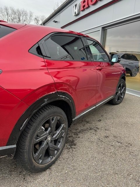 Ein rotes Auto steht vor einem Honda-Händler.