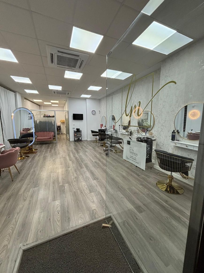 Interior de peluquería con espejos, sillas e iluminación.