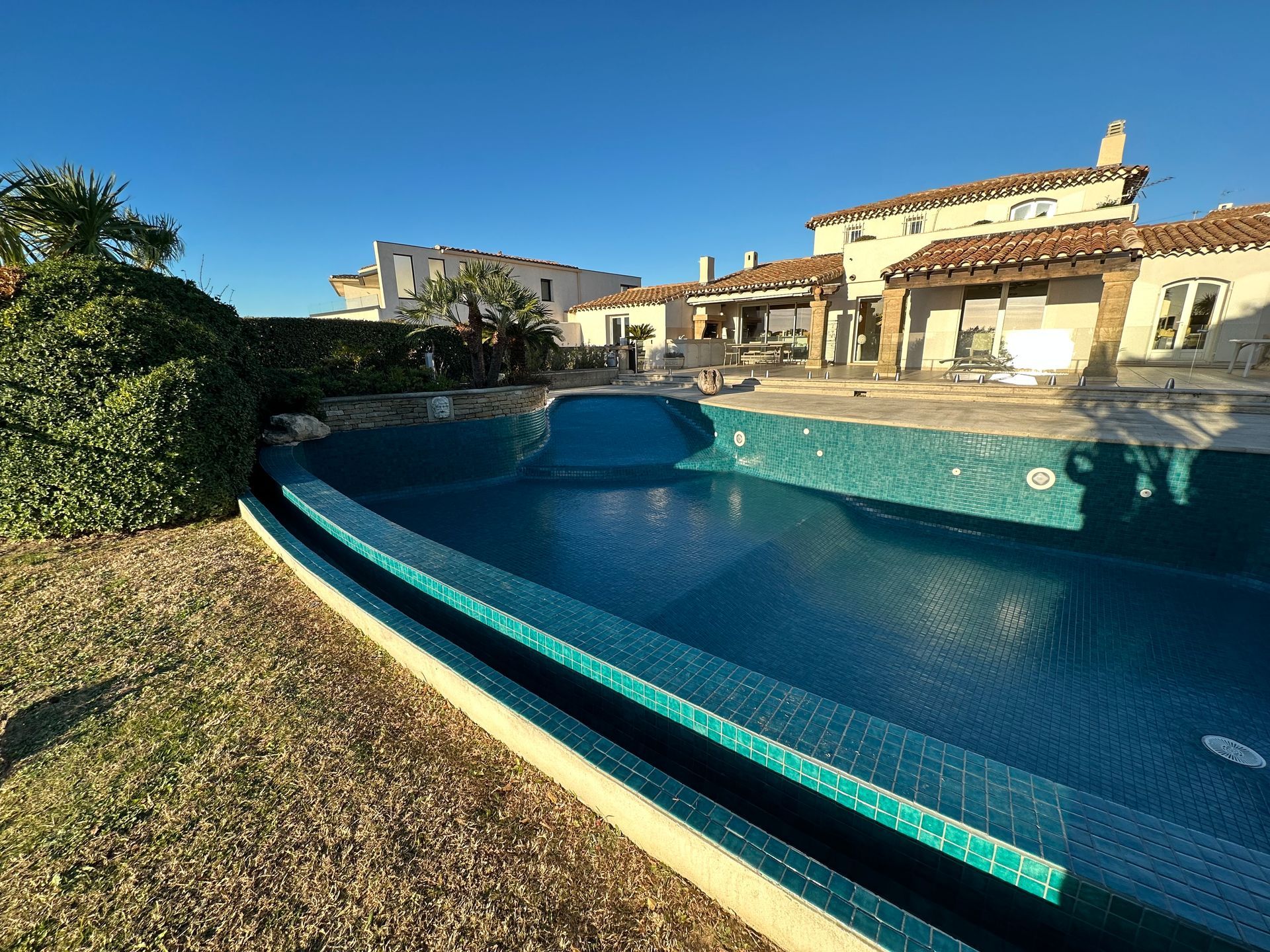 Piscine avec terrasse, transats et bouée
