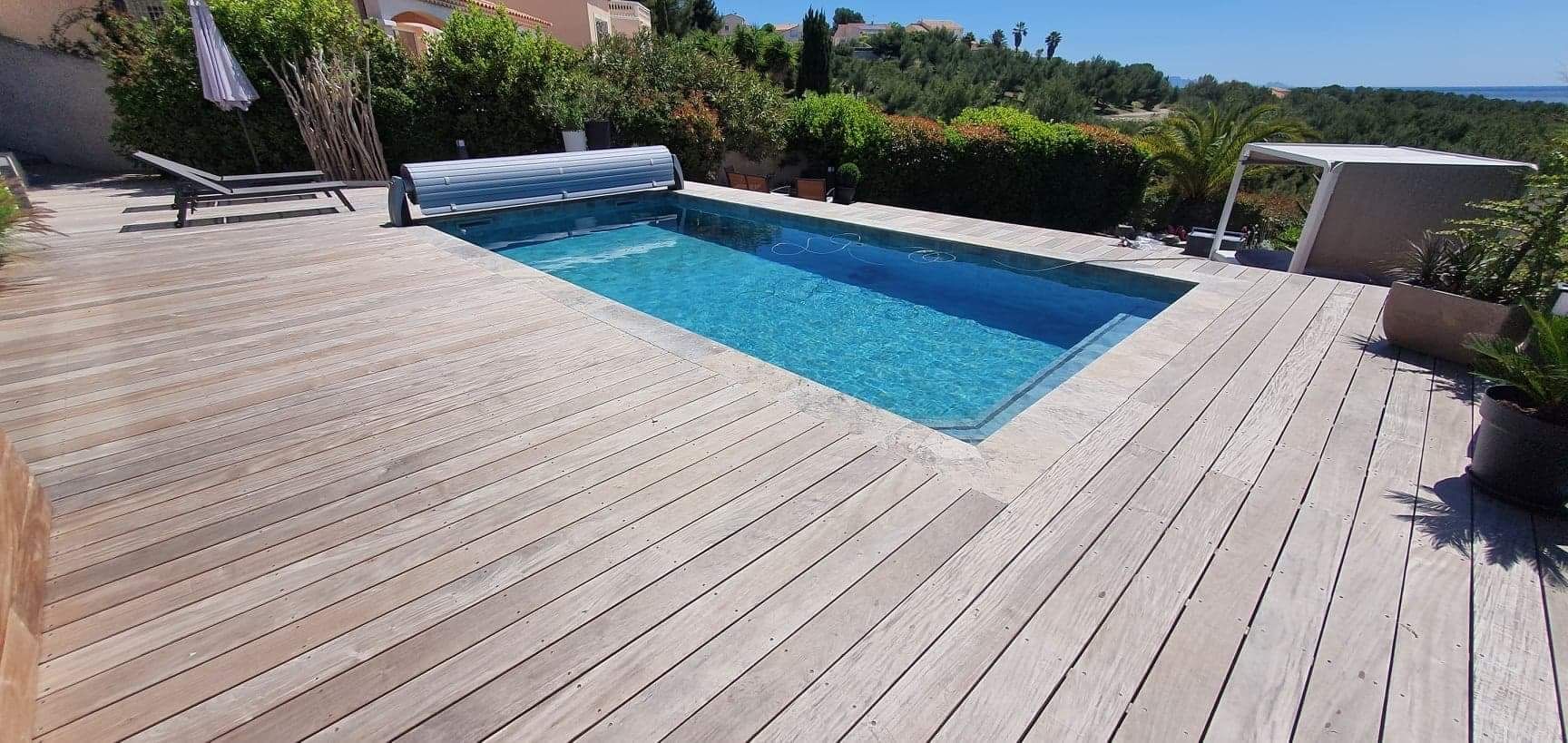 Piscine avec terrasse en bois et volet roulant