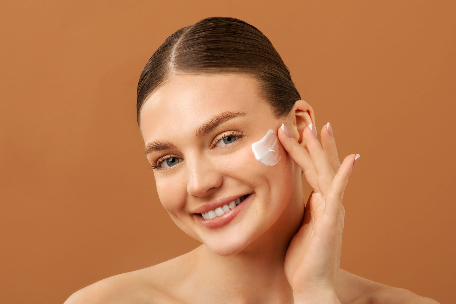 Une femme appliquant de la crème sur son visage