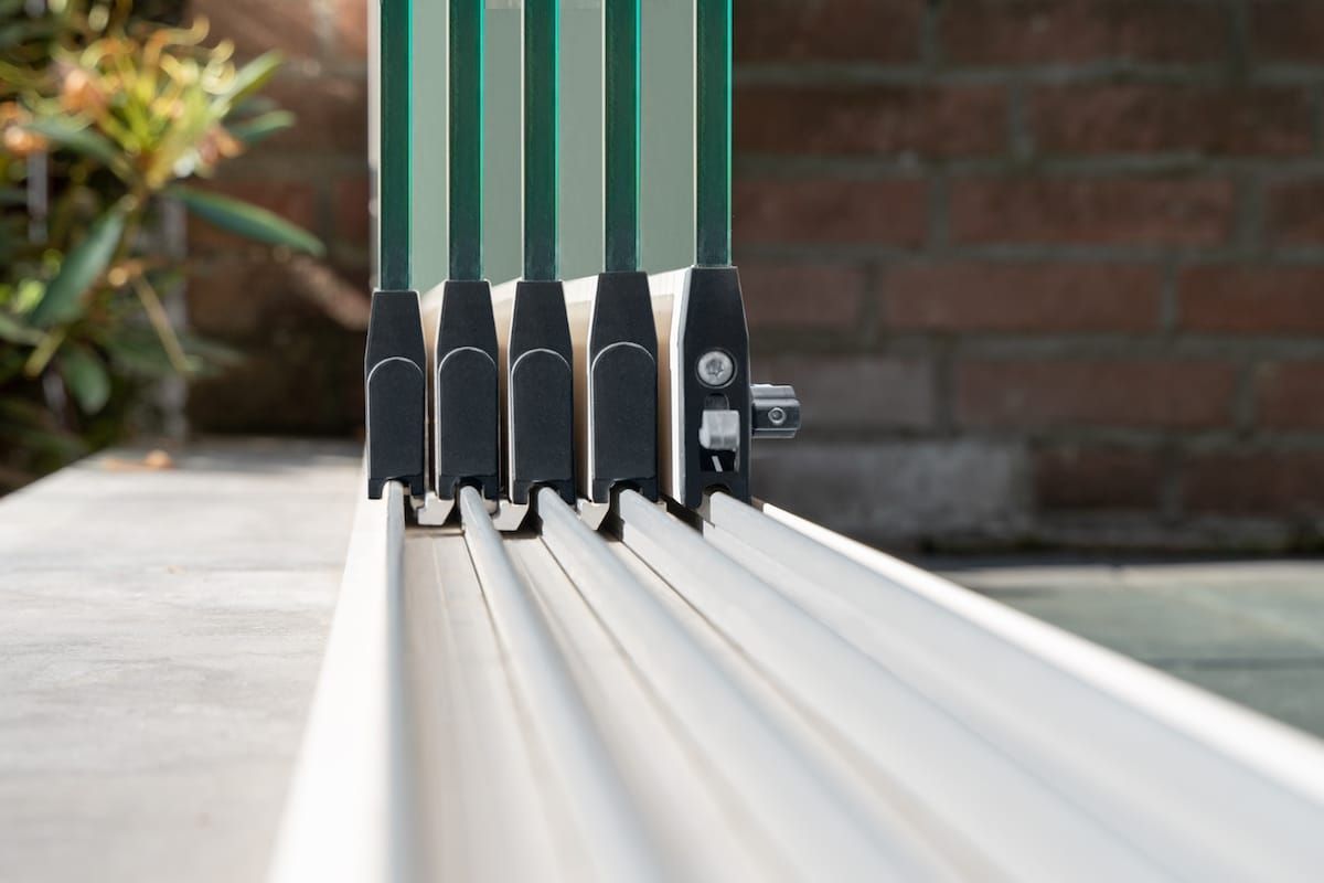 Nahaufnahme aus niedrigem Winkel auf ein mehrspuriges Glasschiebetürsystem, das auf einer Außenterrasse installiert ist.