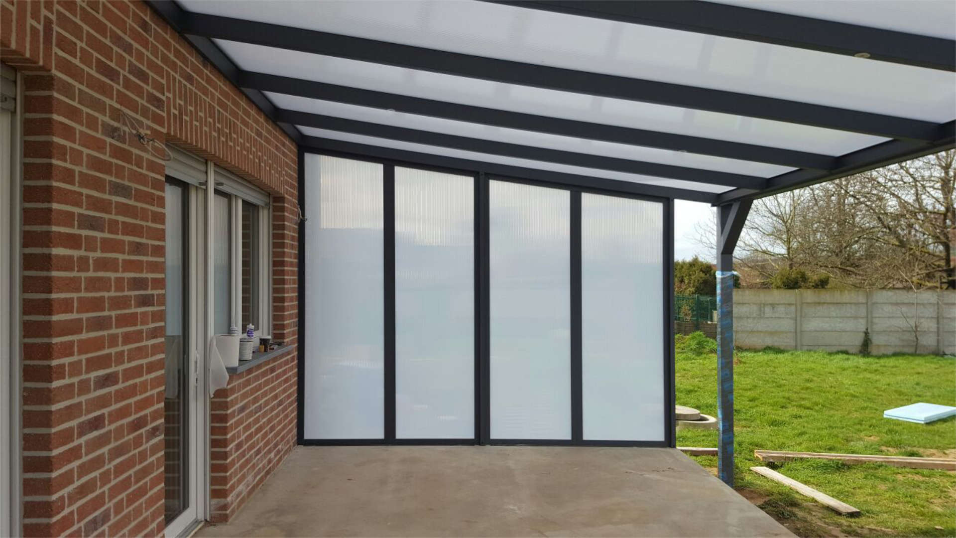 Terassenüberdachung und Trennwand aus Milchglas in einzelnen Segmenten aufgeteilt