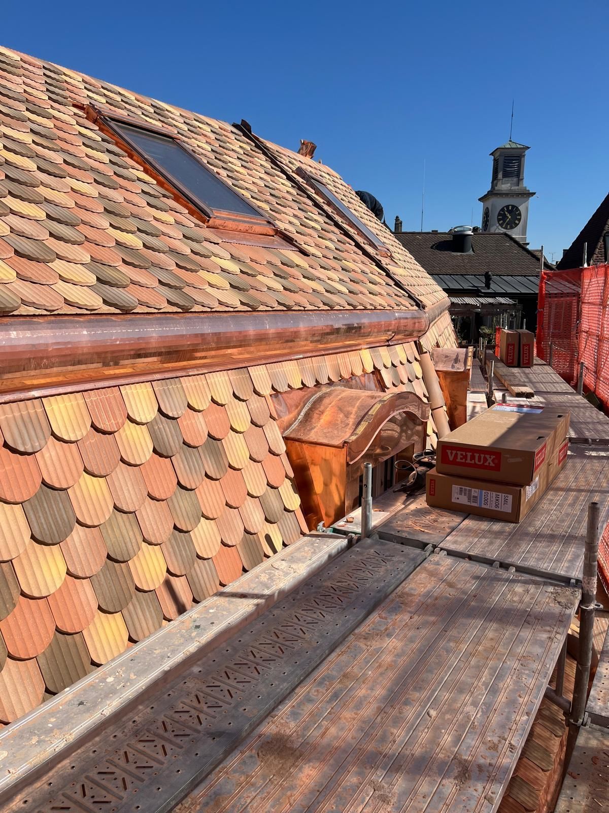 Passerelle sur le toit avec des carreaux à motifs, un puits de lumière et des boîtes en carton sous un ciel bleu