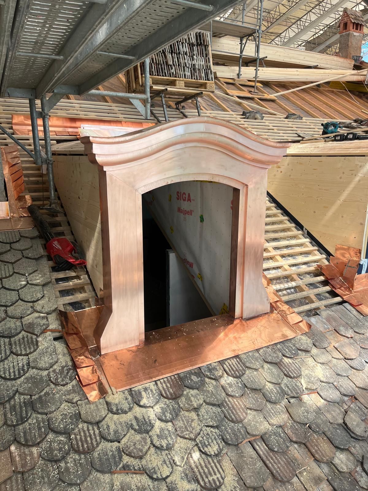 Petite entrée de sanctuaire blanche sur un toit, avec un escalier sombre sous un auvent métallique