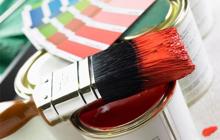 Una lata de pintura roja con un pincel dentro