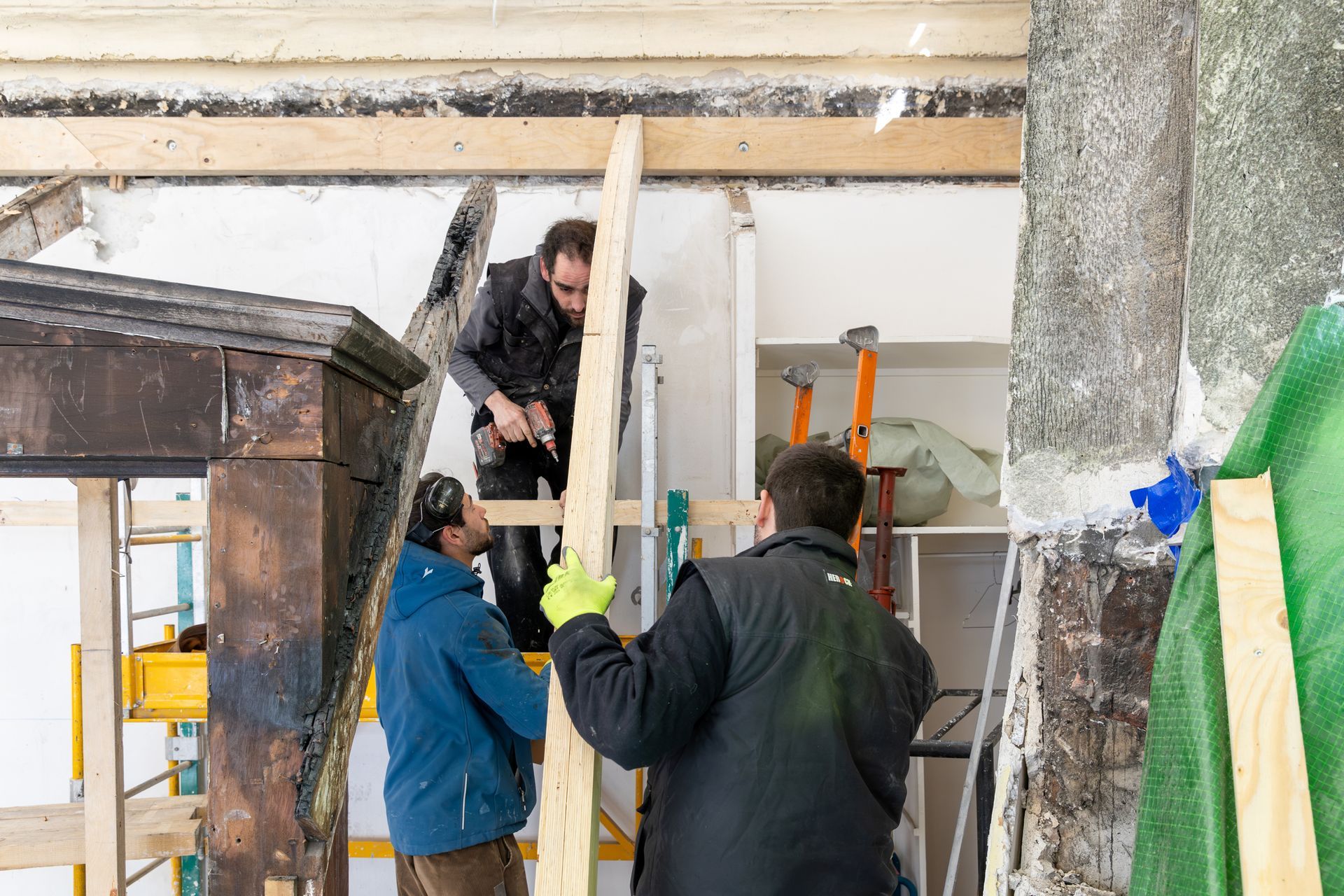 Trois employés mettant en place une structure en bois